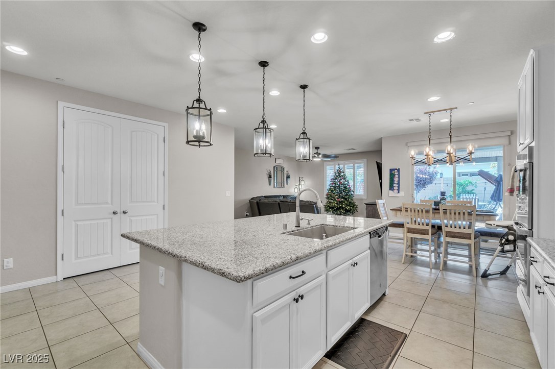 119 Mosso Niente Place Henderson, NV 89011 - Photo 7 of 36 Kitchen with white cabinetry, light tile patterned floors, recessed lighting, light stone counters, and decorative light fixtures