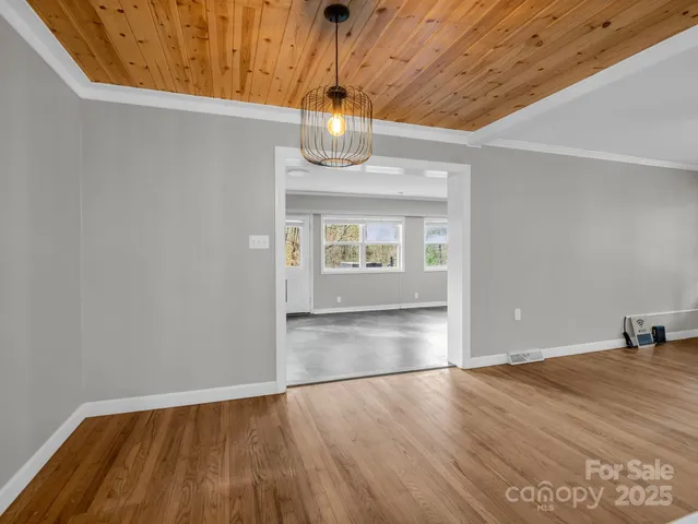 a view of empty room with wooden floor