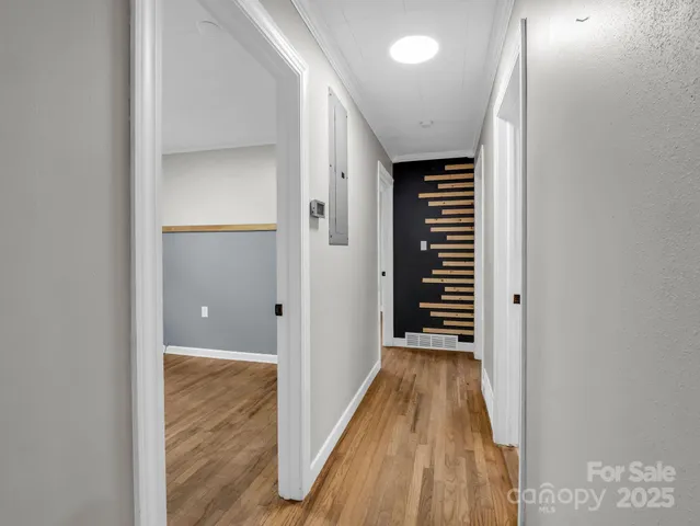 a view of a hallway with wooden floor and closet