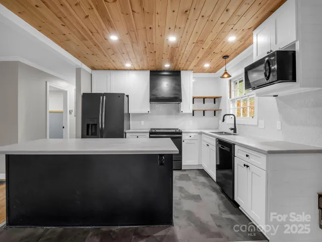 a kitchen with white cabinets sink and stainless steel appliances