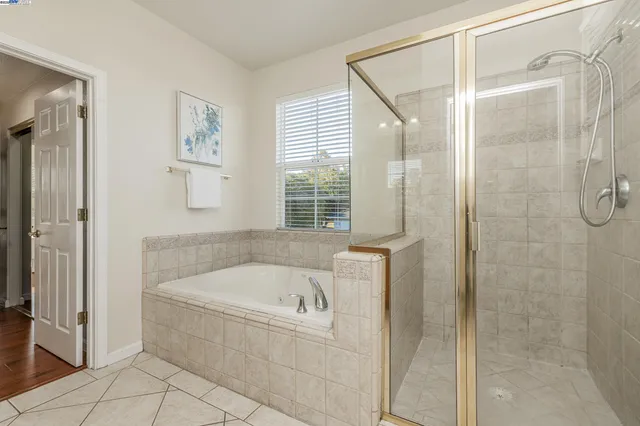 a spacious bathroom with a tub sink shower and mirror