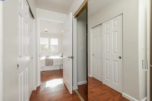 a spacious bedroom with a bed and wooden floor