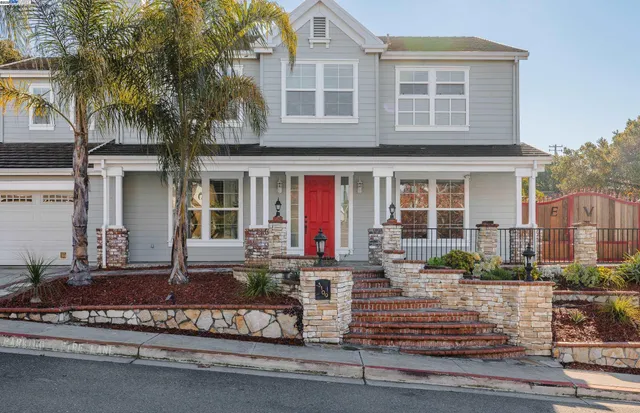 a front view of a house with lots of windows and plants