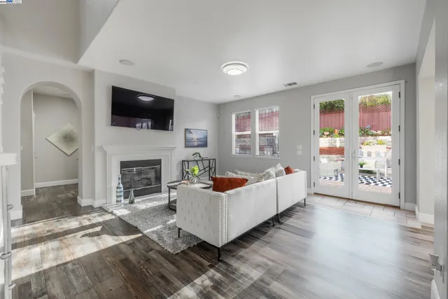 a living room with furniture a flat screen tv and a fireplace