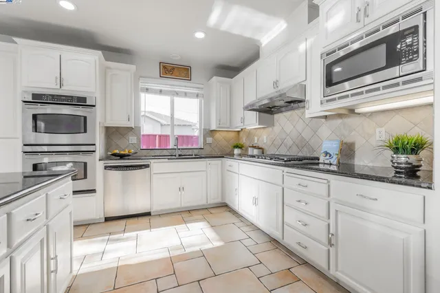 a kitchen with stainless steel appliances granite countertop a sink and cabinets