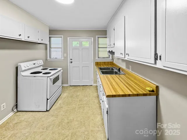 a kitchen with granite countertop white cabinets and white appliances