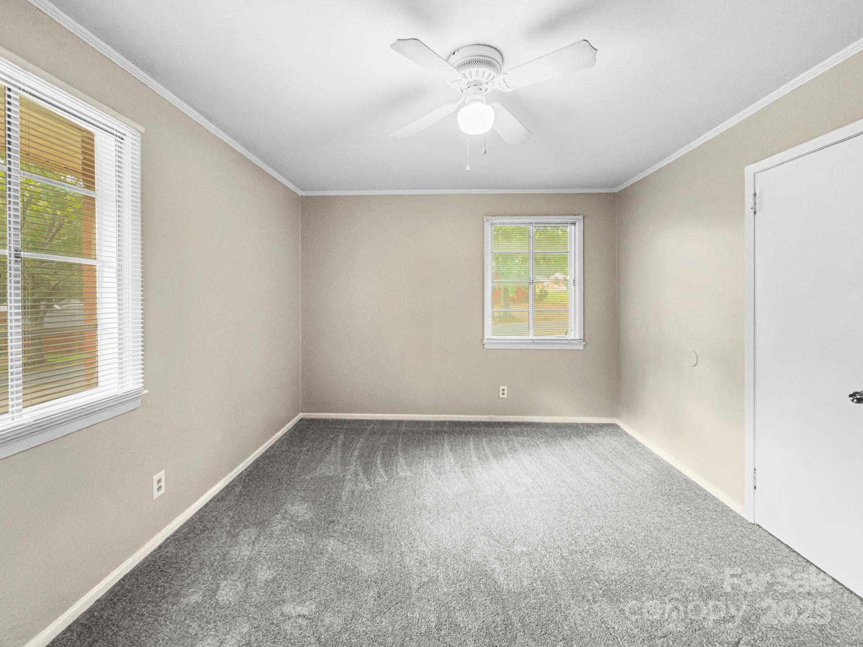 3014 Marlborough Road Charlotte, NC 28208 - Photo 5 of 20 an empty room with windows and fan