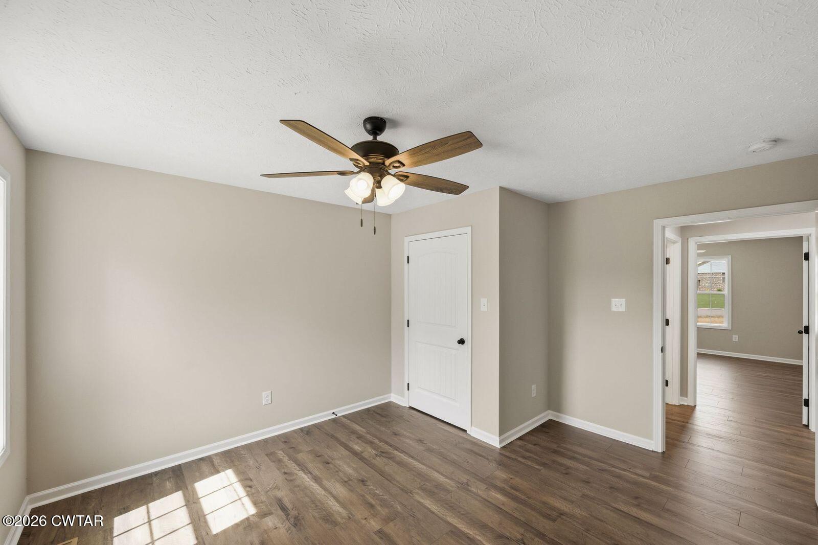 435 Old Huntingdon Road Lexington, TN 38351 - Photo 11 of 26 an empty room with wooden floor and a ceiling fan