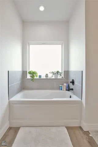 a bathroom with a bathtub and window