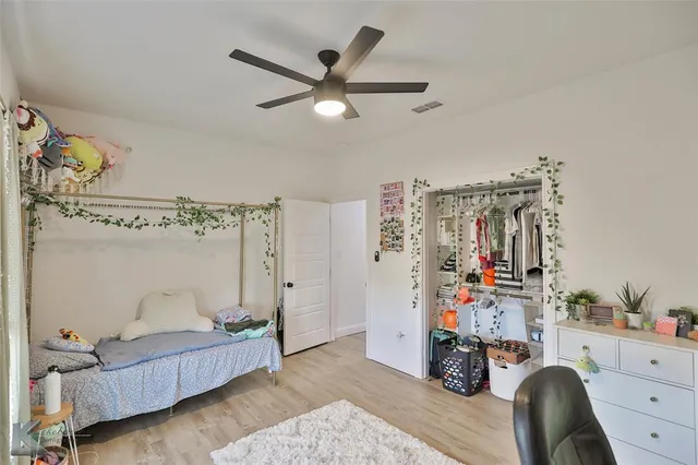 a bedroom with furniture and a fan