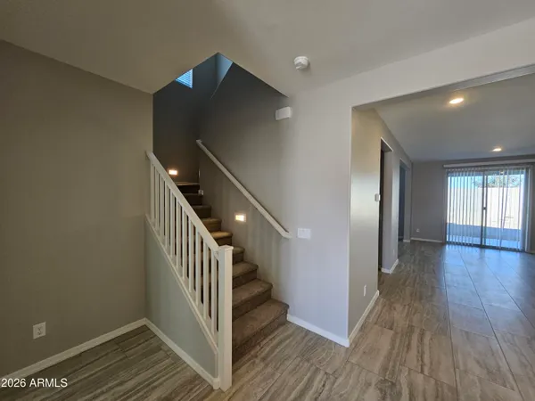 a view of a hallway with wooden floor and staircase