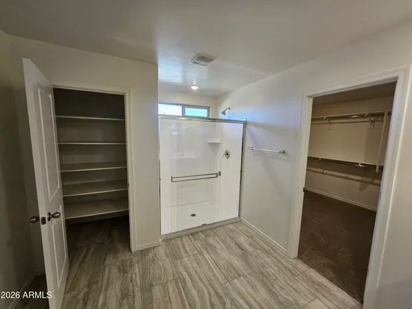 a view of walk in closet with empty racks