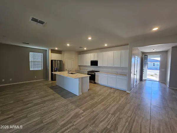 a large kitchen with stainless steel appliances granite countertop a large counter top a stove and a wooden floors