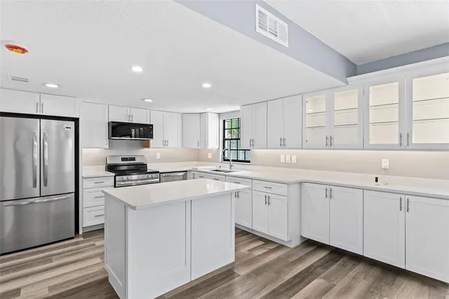 a view of a hallway with wooden floor and cabinet