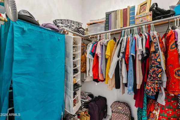 a view of walk in closet with clothes and shoes
