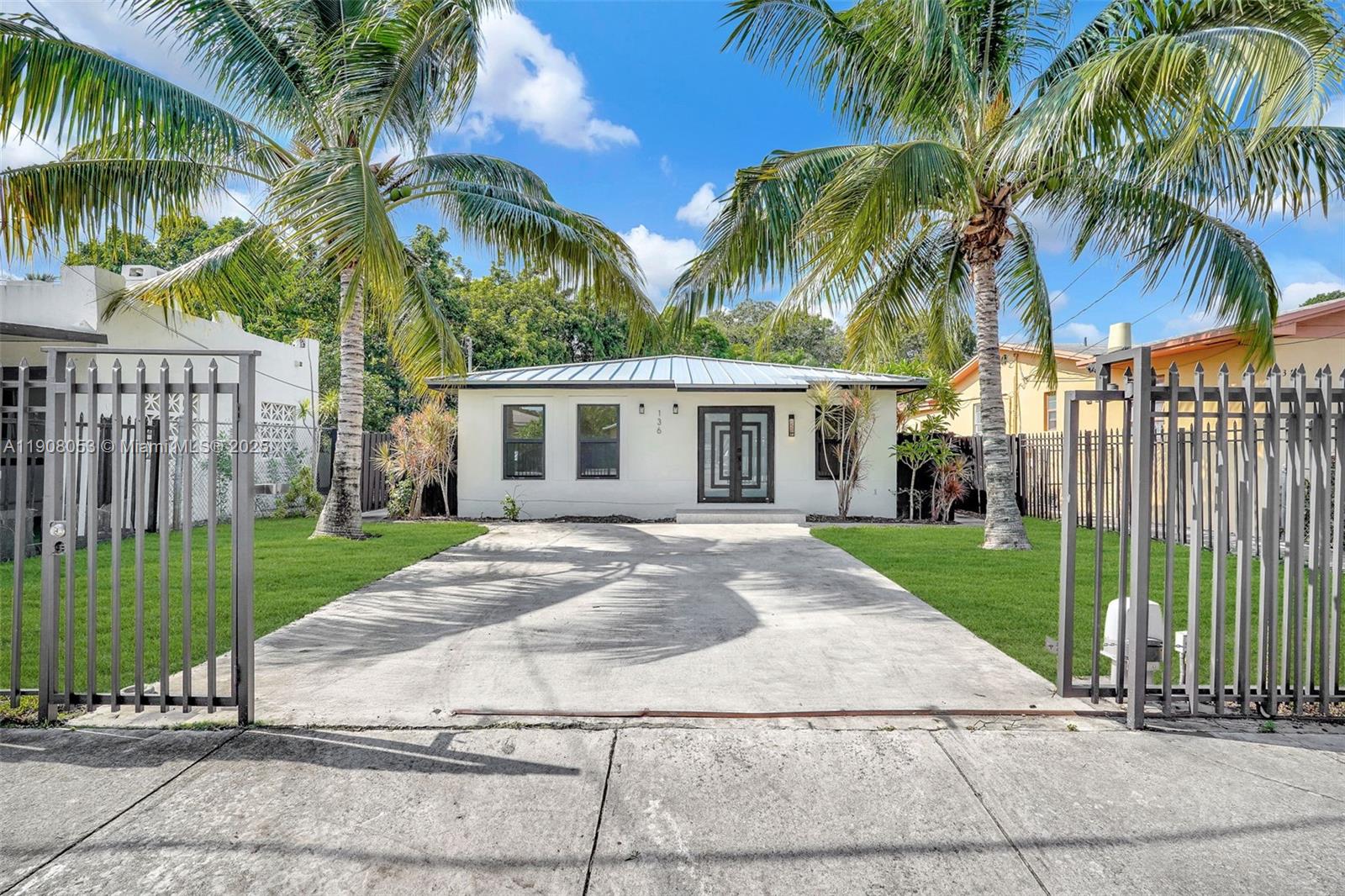 a view of a house with a yard and a palm trees