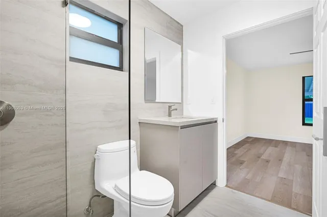 a bathroom with a toilet a sink and mirror