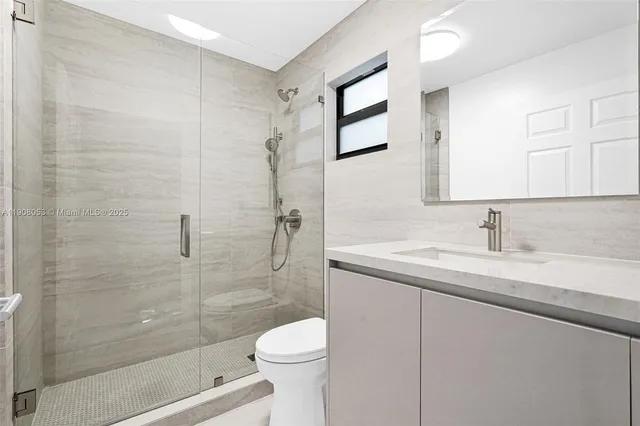 a bathroom with a sink a toilet and shower