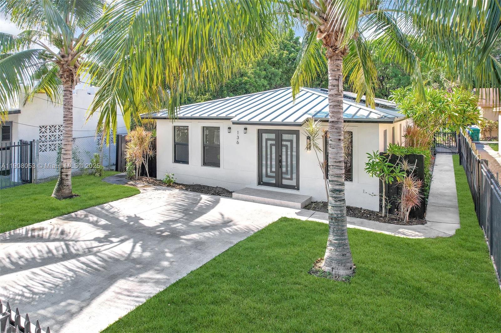 136 Northwest 53rd Street Miami, FL 33127 - Photo 3 of 28 a front view of a house with a garden