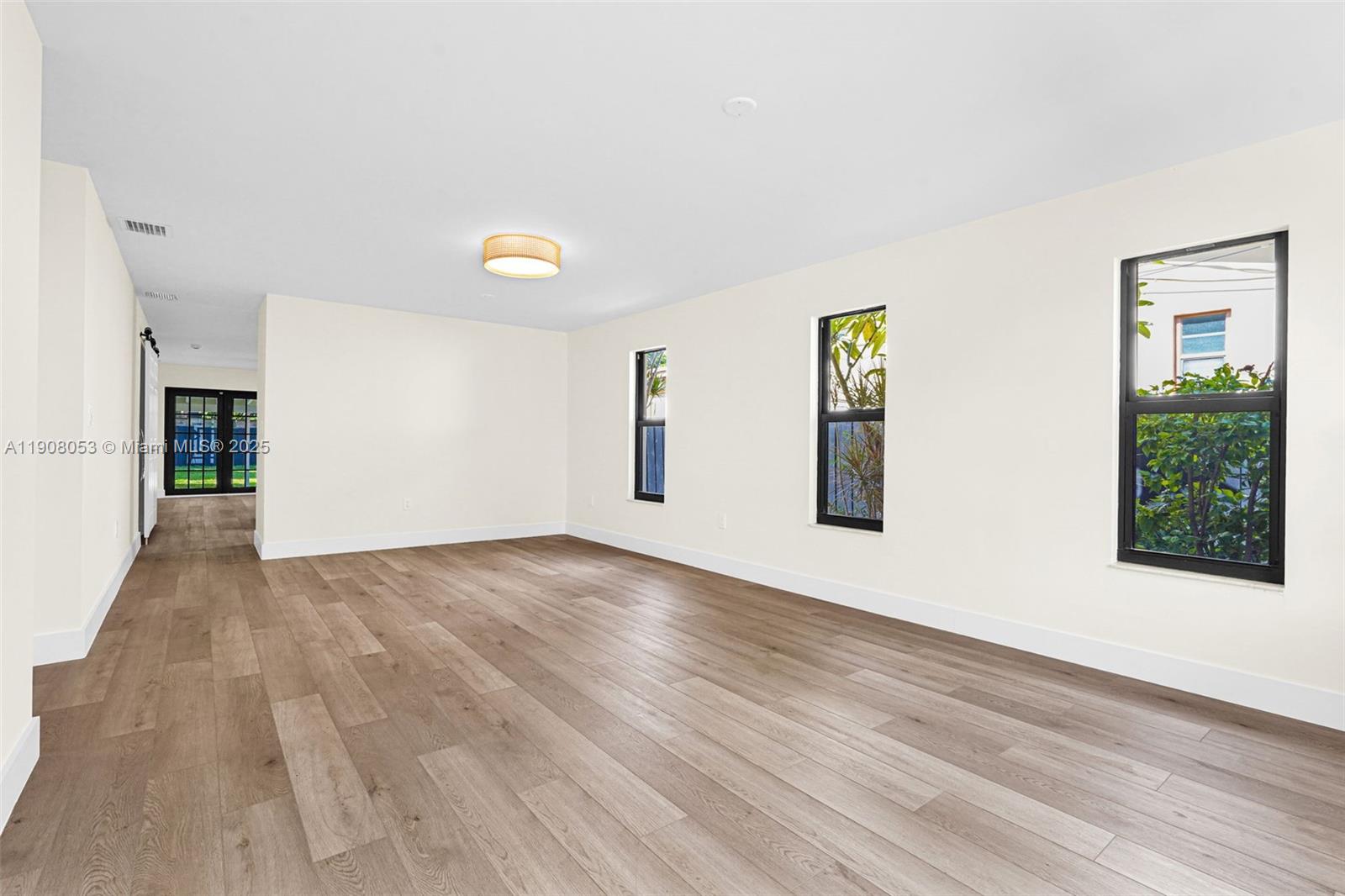 136 Northwest 53rd Street Miami, FL 33127 - Photo 6 of 28 a view of an empty room with wooden floor and a window