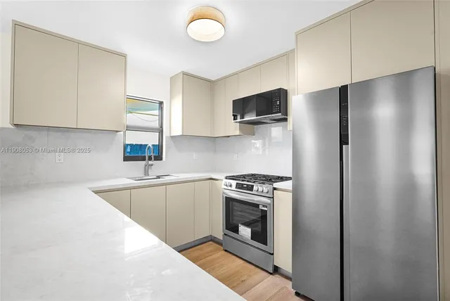 a kitchen with a stove a refrigerator and a sink