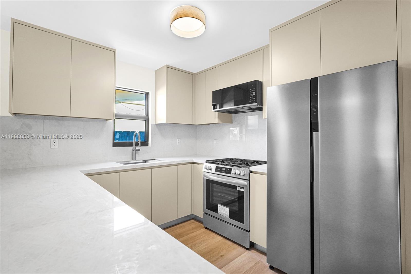 136 Northwest 53rd Street Miami, FL 33127 - Photo 8 of 28 a kitchen with a stove a refrigerator and a sink