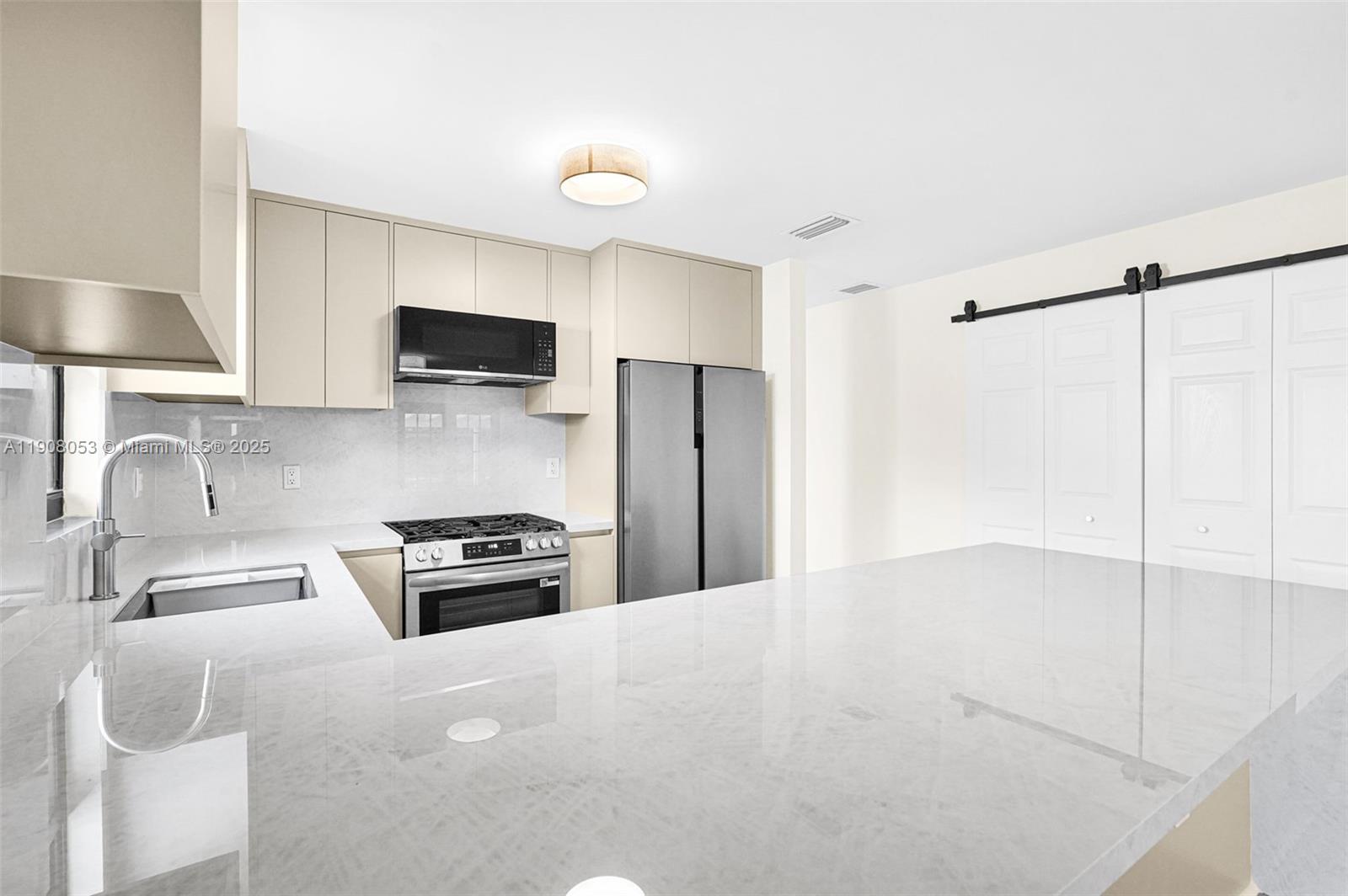 136 Northwest 53rd Street Miami, FL 33127 - Photo 9 of 28 a kitchen with granite countertop a sink a stove and refrigerator