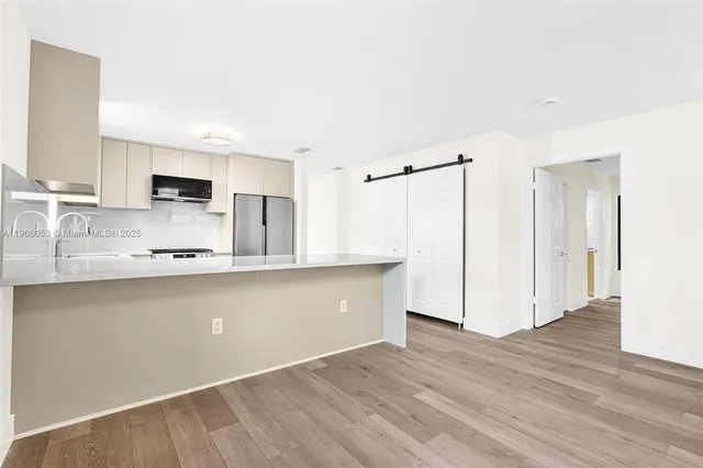 a kitchen with granite countertop a refrigerator and a stove top oven