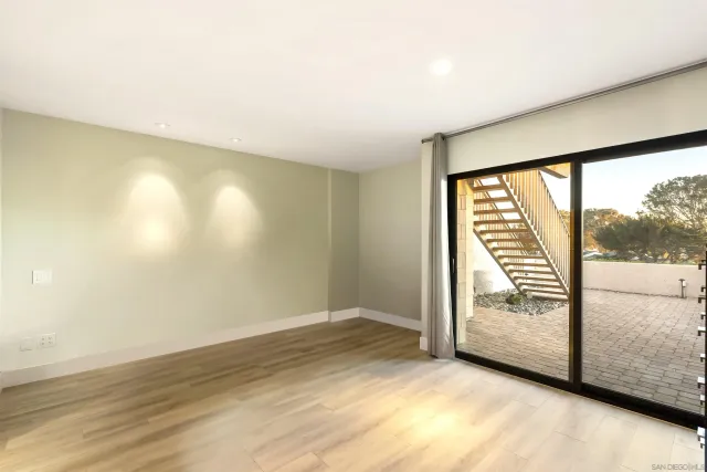 an empty room with wooden floor and door