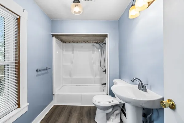 a bathroom with a sink toilet a mirror and bathtub