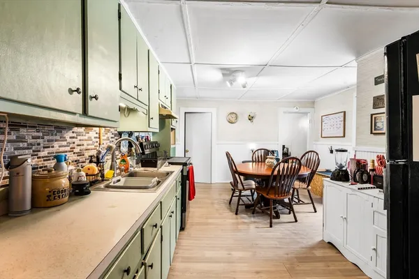 a view of a dining room with furniture a kitchen and chandelier