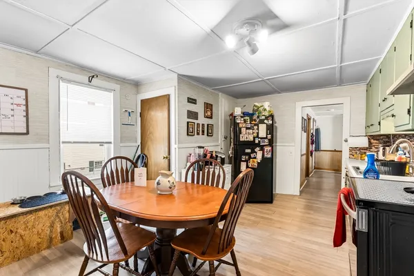 a dining room with furniture window and wooden floor