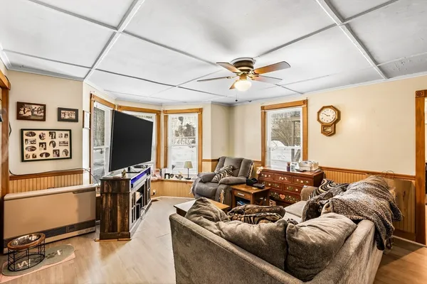 a living room with furniture a flat screen tv and a window