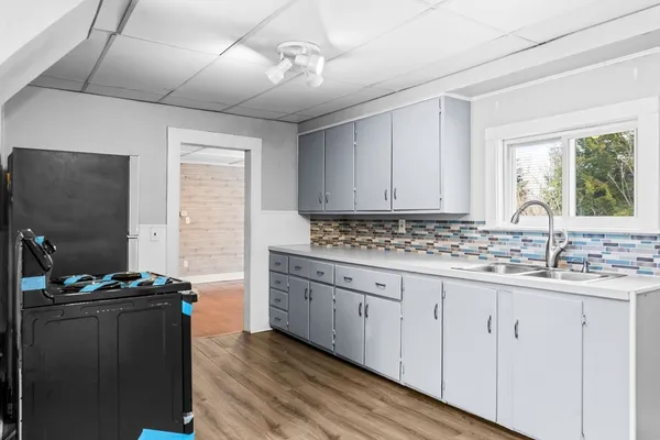 a kitchen with granite countertop a sink and a stove top oven