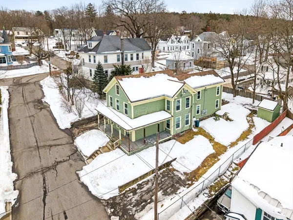 a view of a white house with large windows next to a road