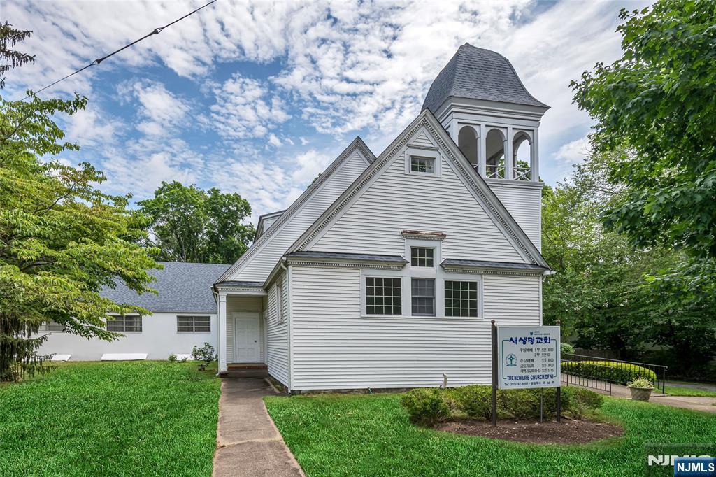 283 Harrington Avenue Closter, NJ 07624 - Photo 4 of 17 a front view of a house with a garden and plants
