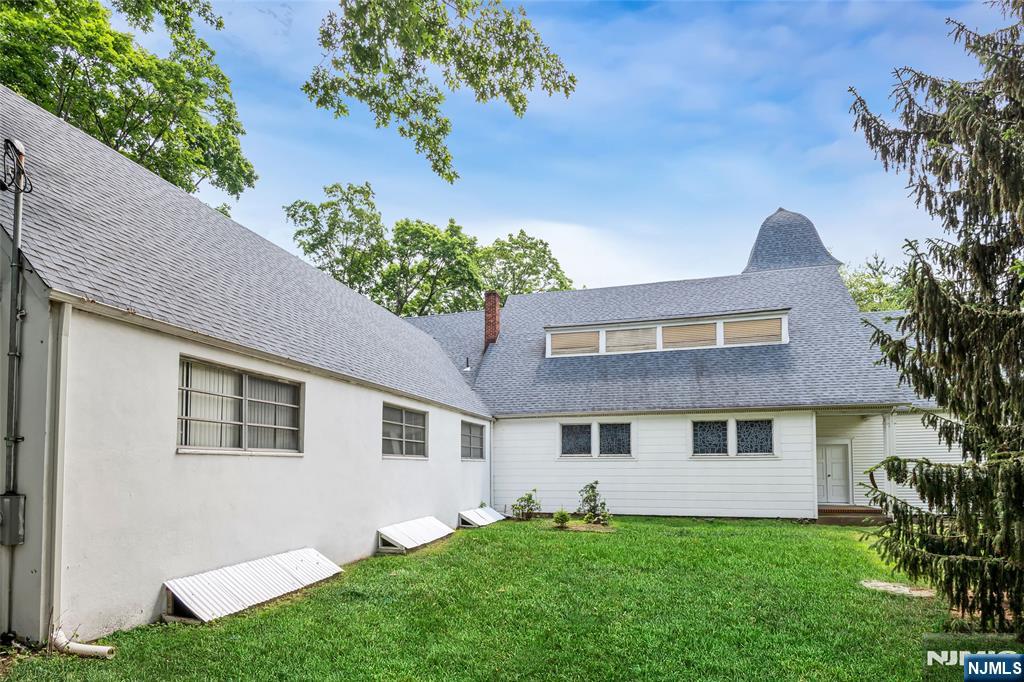 283 Harrington Avenue Closter, NJ 07624 - Photo 7 of 17 a front view of a house with a garden and yard