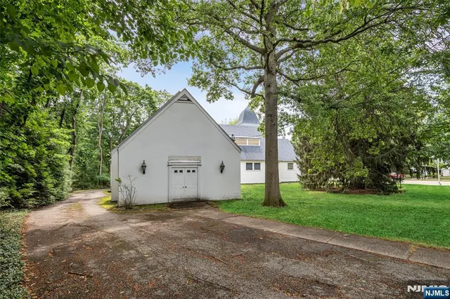 a view of a house with a yard and large trees
