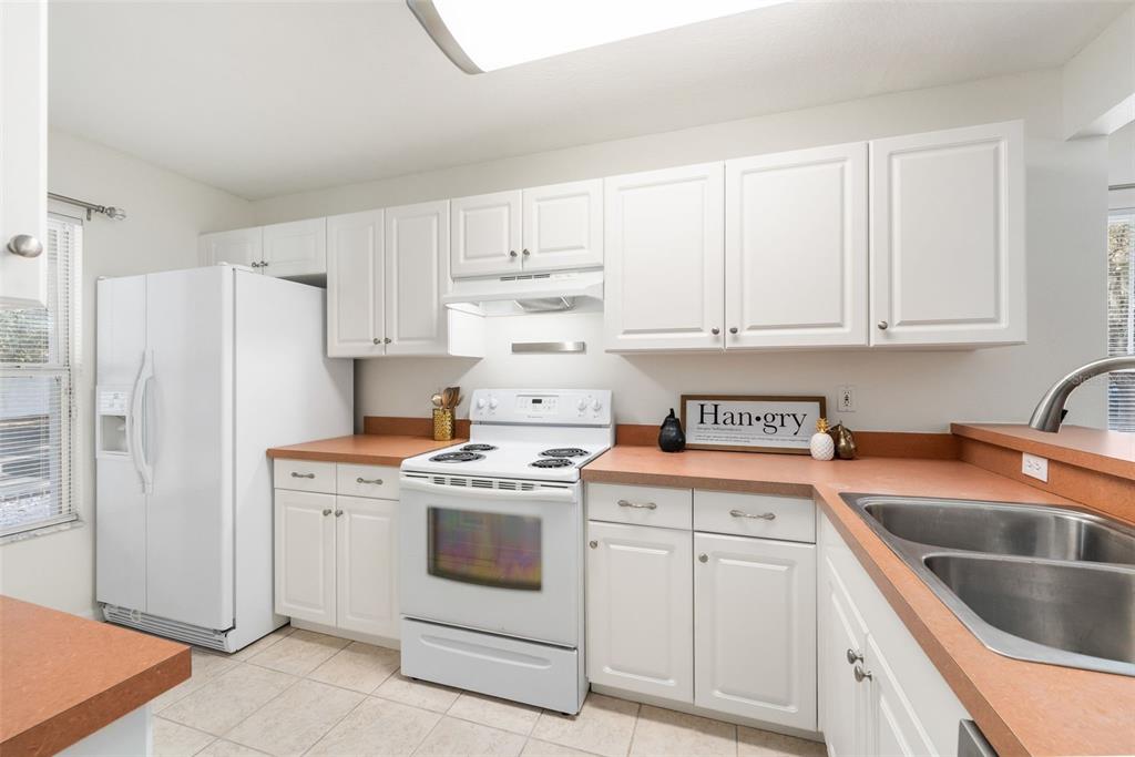 2348 Southwest 42nd Drive, Unit 154 Gainesville, FL 32607 - Photo 15 of 35 a kitchen with stainless steel appliances granite countertop a stove a refrigerator a sink a stove and white cabinets