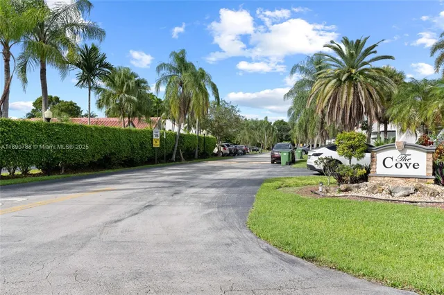 a view of a swimming pool with a garden and palm trees
