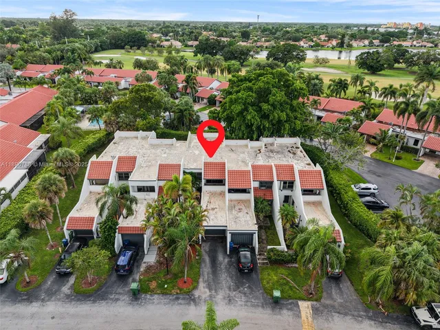 an aerial view of a city with lots of residential buildings ocean and mountain view in back