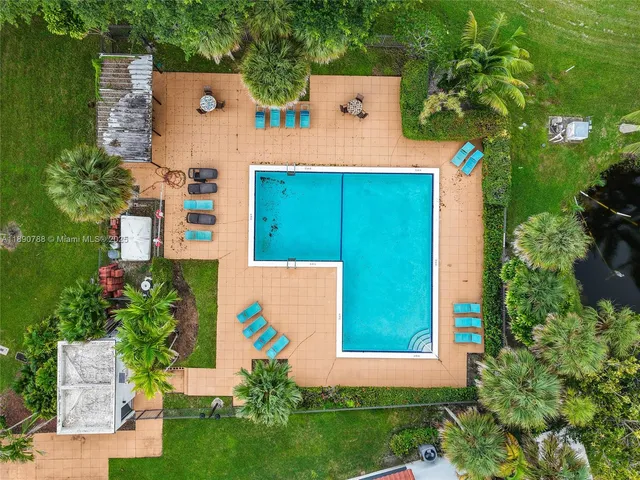 an aerial view of a house with a garden and lake view
