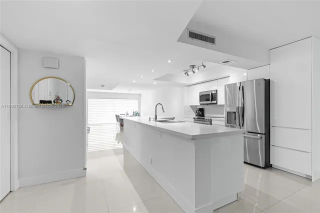 a kitchen with refrigerator cabinets and a sink