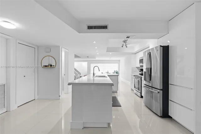 a kitchen with stainless steel appliances granite countertop a refrigerator and a sink