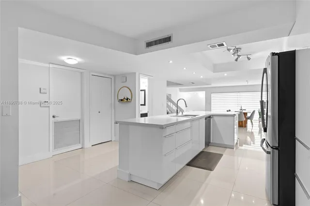 a large white kitchen with a white stove top oven and refrigerator