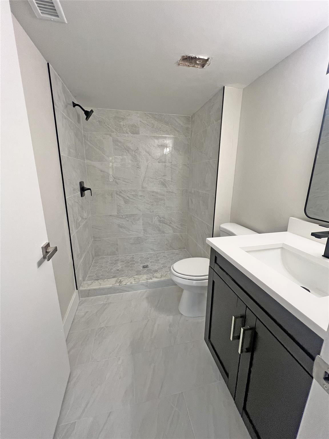 9055 Wiles Road, Unit 208 Coral Springs, FL 33067 - Photo 12 of 35 a bathroom with a sink a toilet and shower