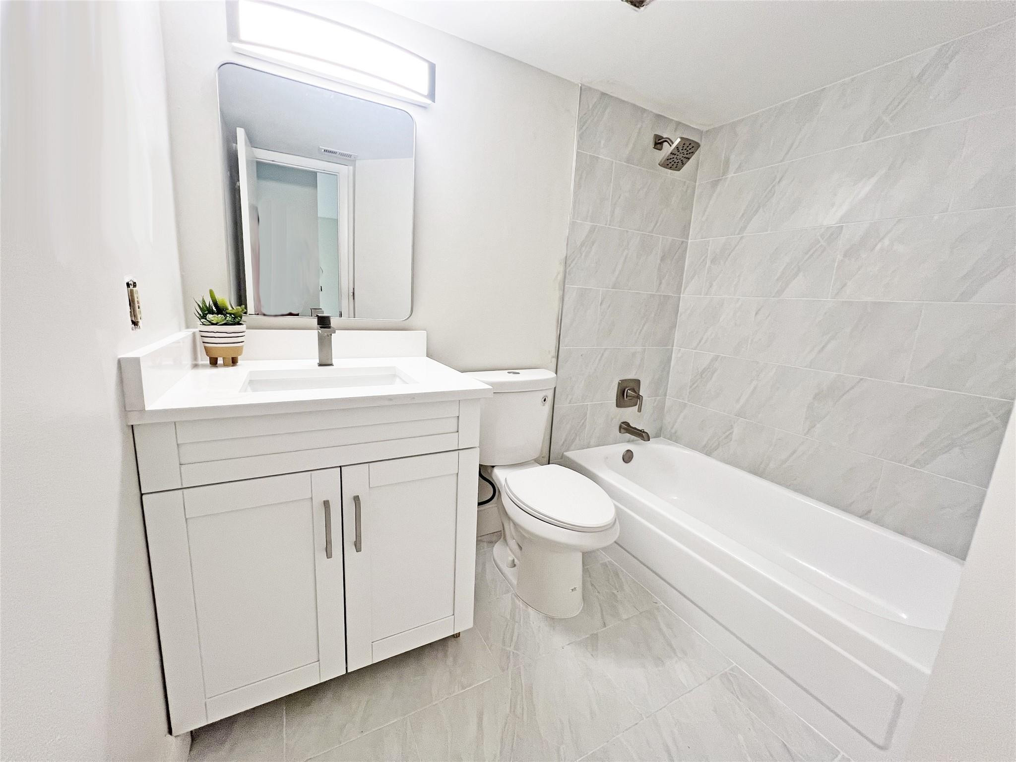 9055 Wiles Road, Unit 208 Coral Springs, FL 33067 - Photo 18 of 35 a bathroom with a sink a toilet and a bathtub