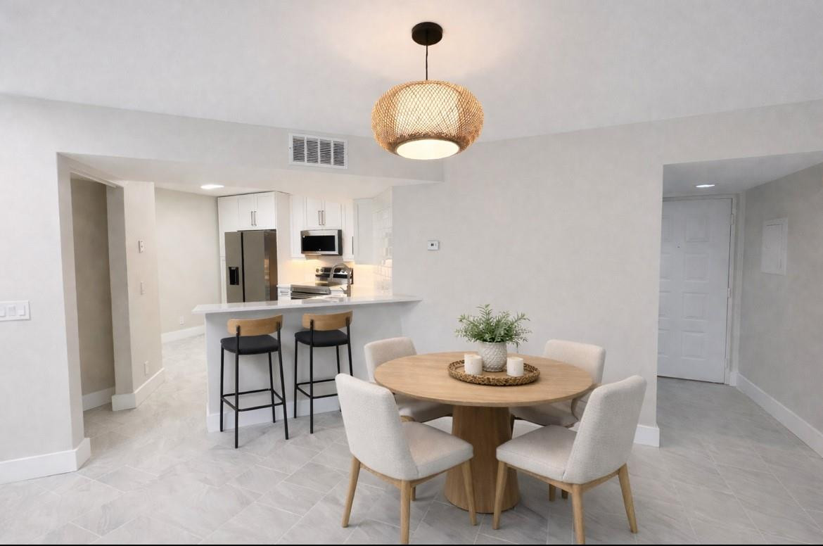 9055 Wiles Road, Unit 208 Coral Springs, FL 33067 - Photo 2 of 35 a view of a dining room with furniture and wooden floor
