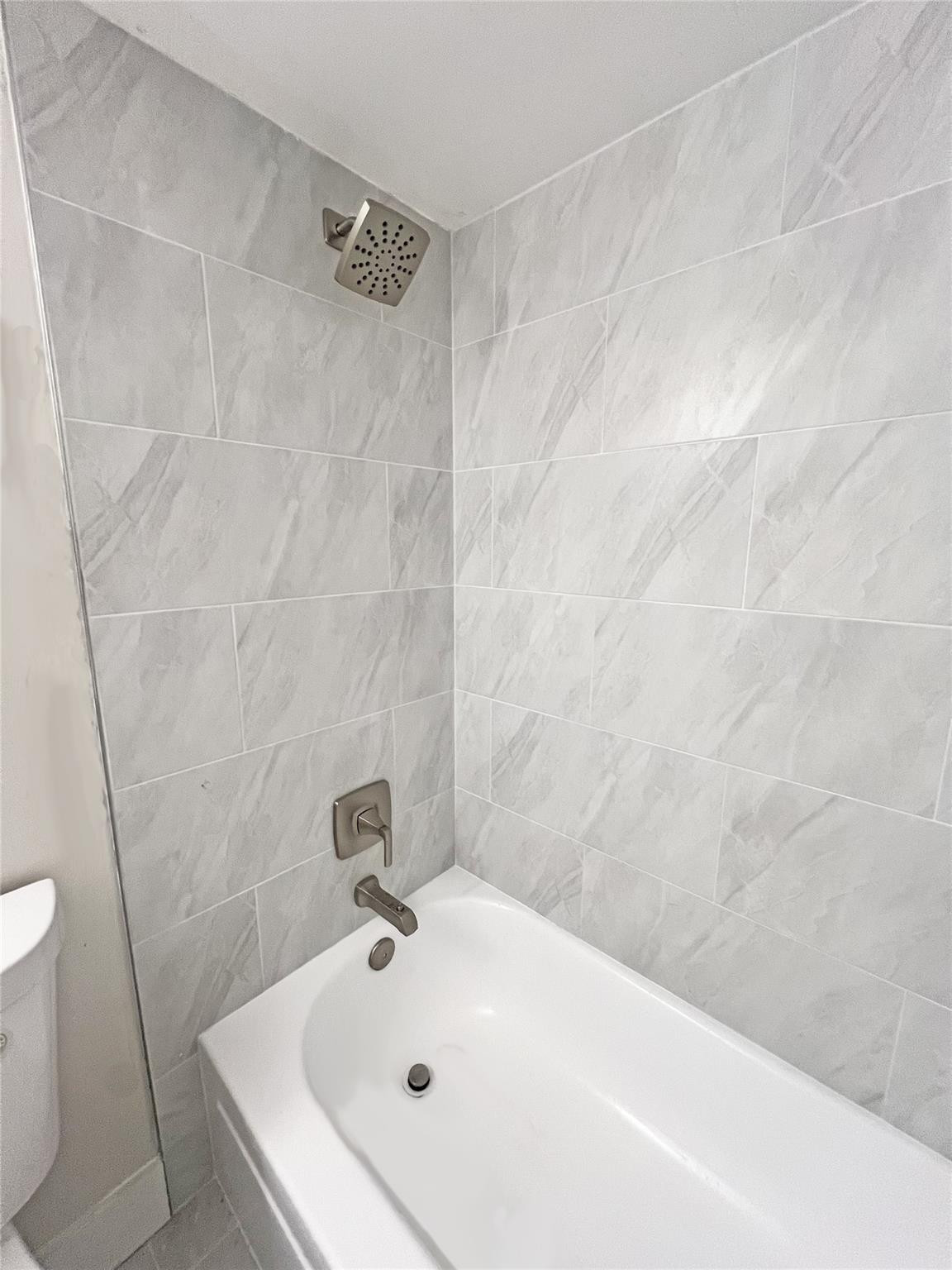 9055 Wiles Road, Unit 208 Coral Springs, FL 33067 - Photo 21 of 35 a white bath tub sitting in a bathroom