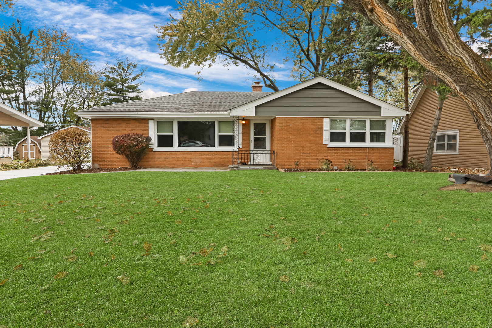 a front view of a house with a yard and trees